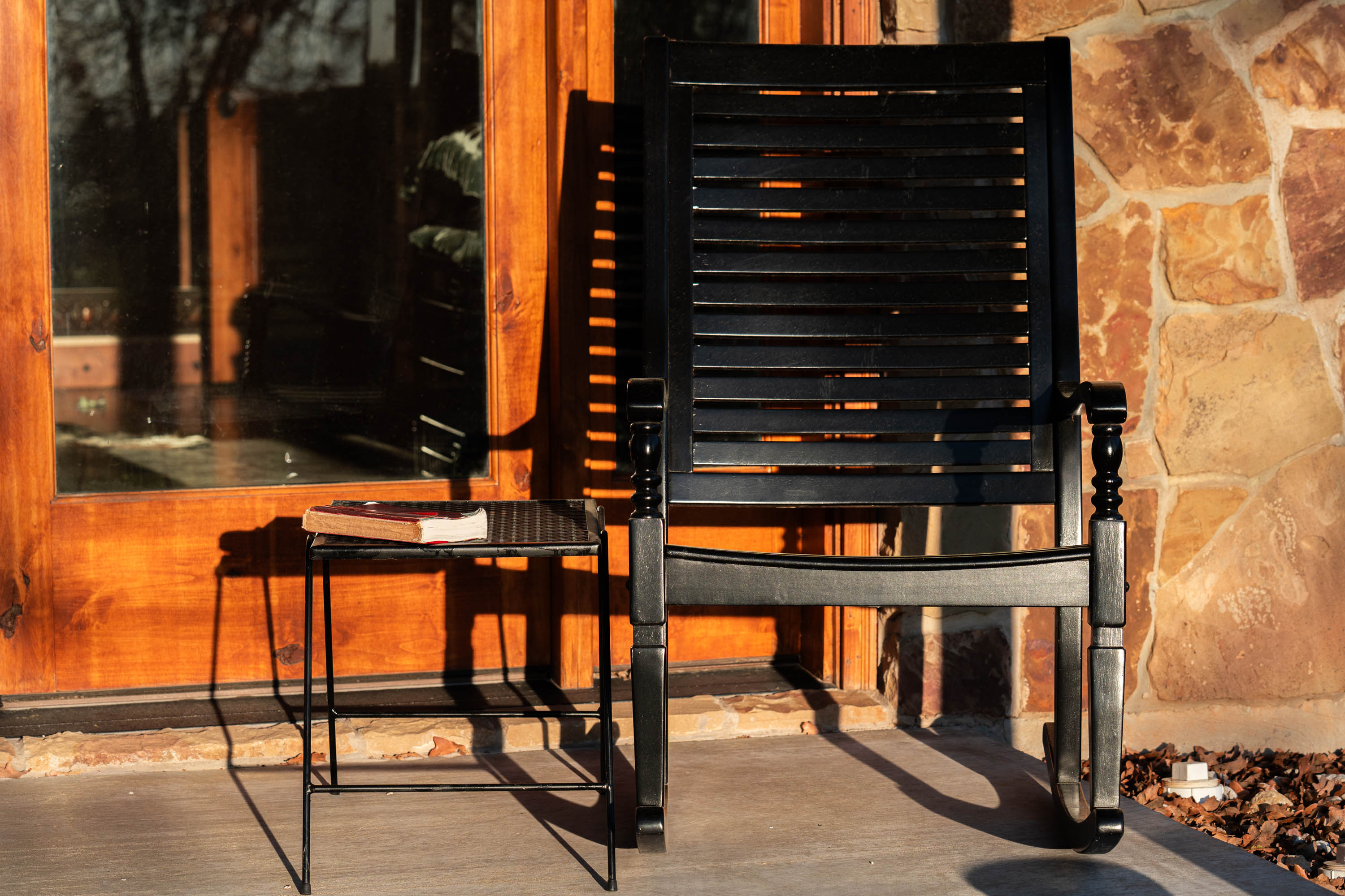 A rocking chair on the porch with a Bible